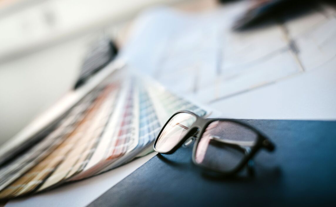 Brille liegt auf Buch vor Farbfächer.